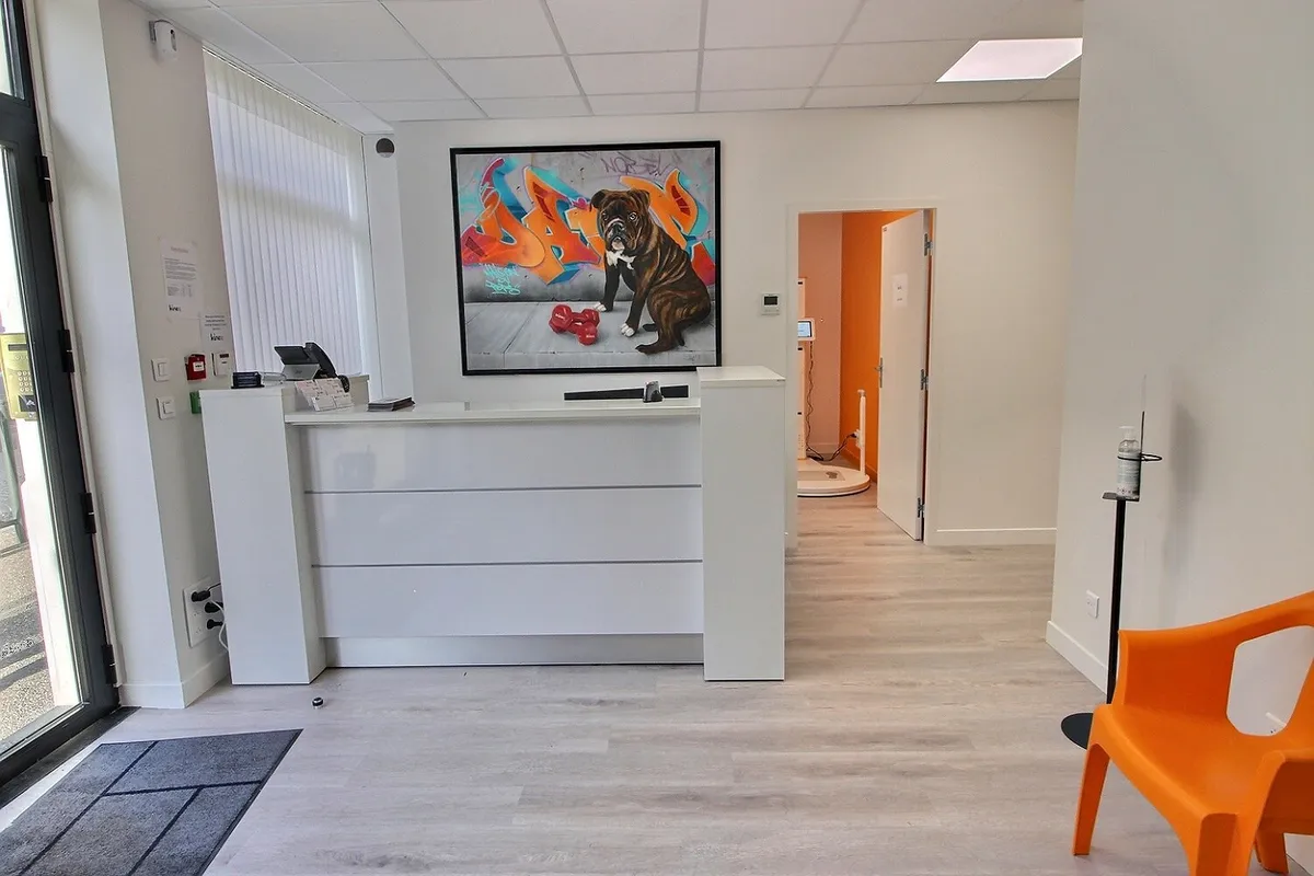 Reception desk at the KinéO2 clinic with graffiti artwork and an orange chair