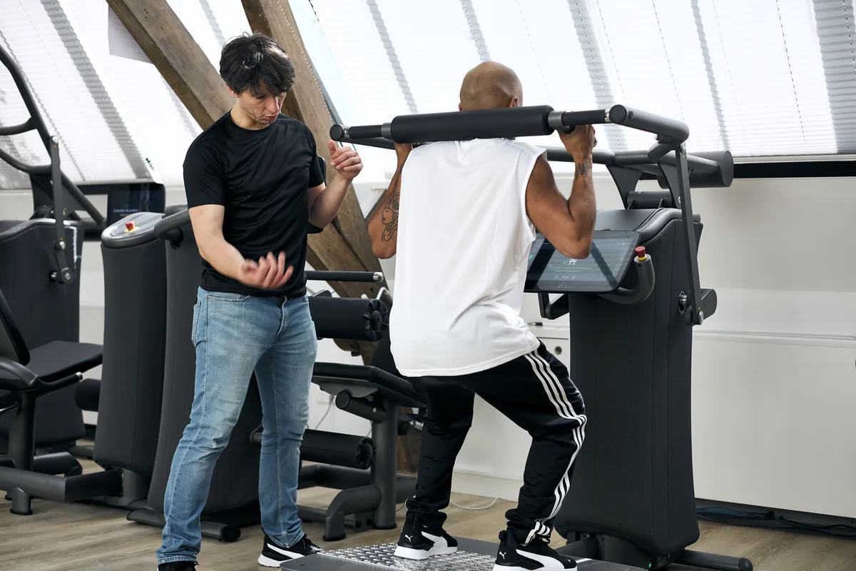Coach Maison du Peps Marais accompagnant adhérent sur machine de musculation guidée